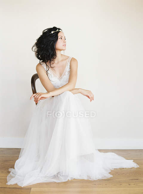 Donna in abito da sposa seduta sulla sedia — Foto stock