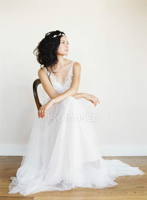 Mulher de vestido de noiva sentado na cadeira — Fotografia de Stock