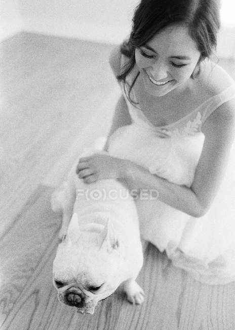 Jeune mariée caressant bulldog — Photo de stock