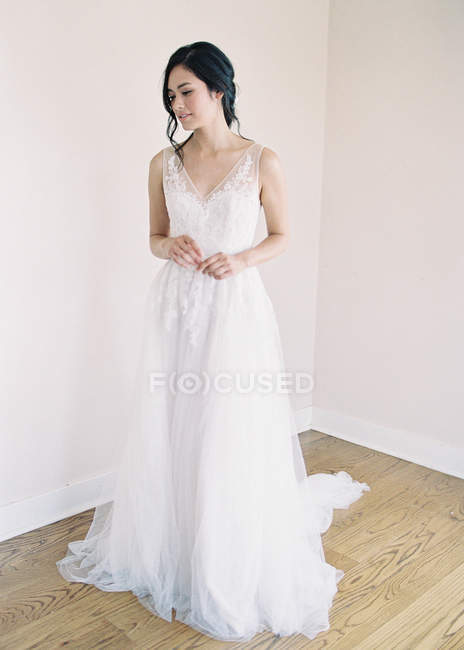Mulher em vestido de noiva de pé no quarto — Fotografia de Stock