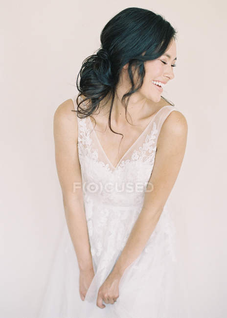 Женщина в свадебном платье смеется — стоковое фото