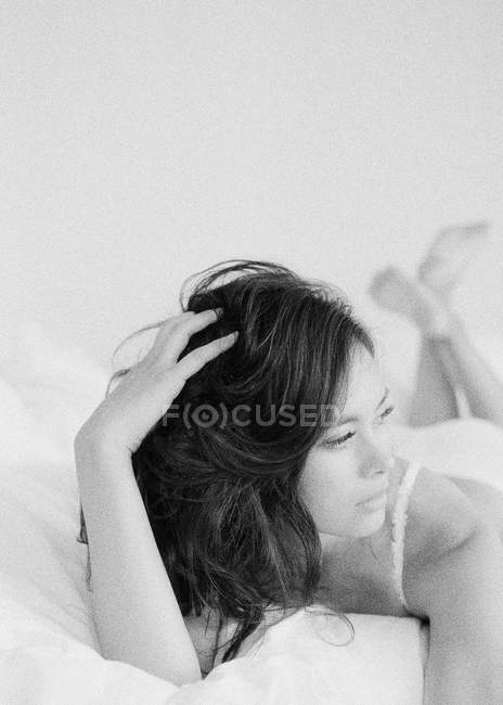 Mulher em lingerie requintada deitada na cama — Fotografia de Stock