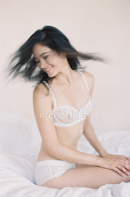 Жінка в вишуканій білизні, що перевертає волосся — стокове фото