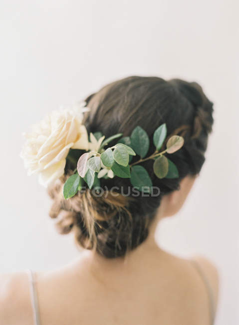 Fiore di rosa e foglie in capelli di donna — Foto stock
