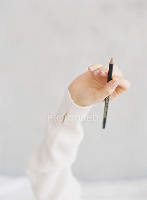 Mano femenina con lápiz - foto de stock