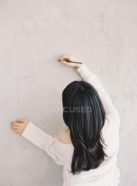 Frau zeichnet an Wand — Stockfoto