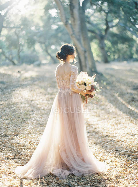 Braut mit Blumenstrauß im Wald — Stockfoto