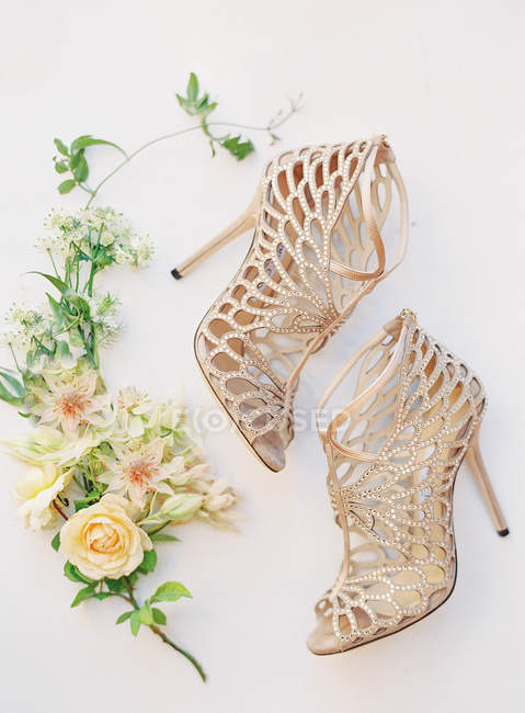 Chaussures de mariée à talons hauts avec des fleurs — Photo de stock
