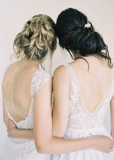 Women in gowns hugging each other — Stock Photo