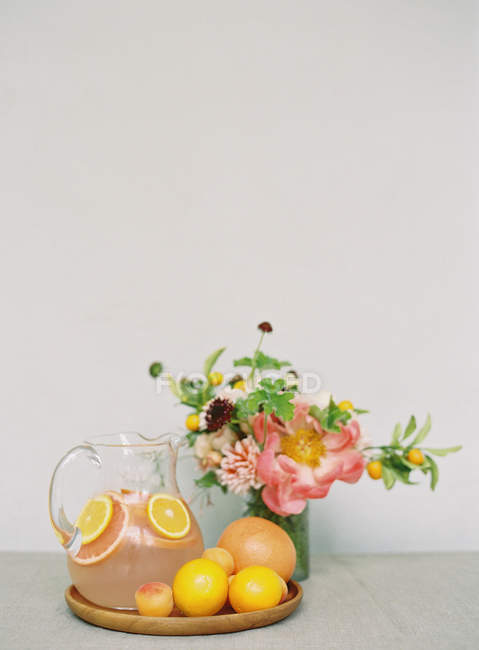 Свежий напиток с апельсинами и букет — стоковое фото