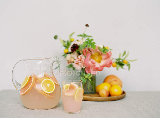 Bebida fresca con naranjas y ramo - foto de stock
