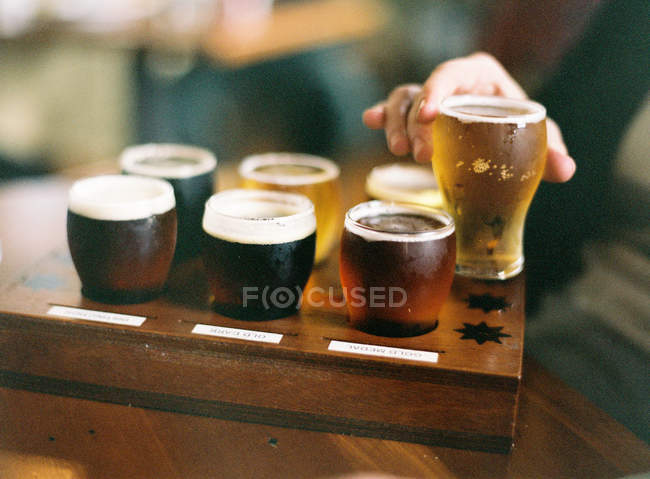 Different kinds of beer in wooden box — Stock Photo