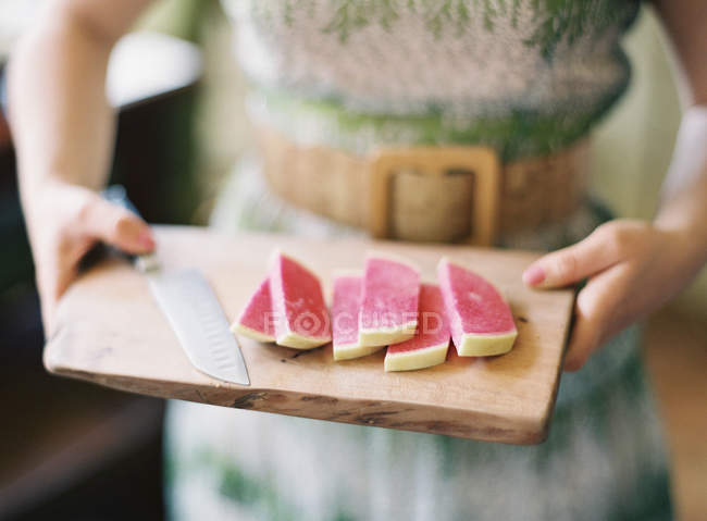 Sliced cheese on cutting board — Stock Photo