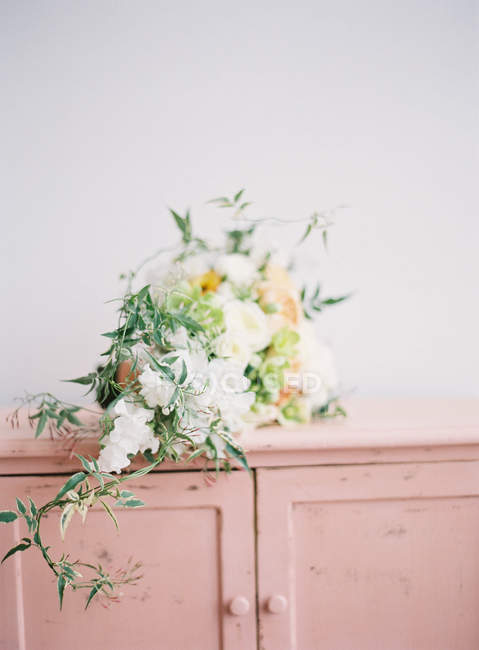 Elegant bouquet on vintage cupboard — Stock Photo