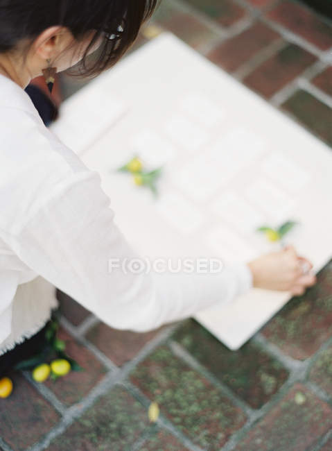Woman placing olives on paper — Stock Photo