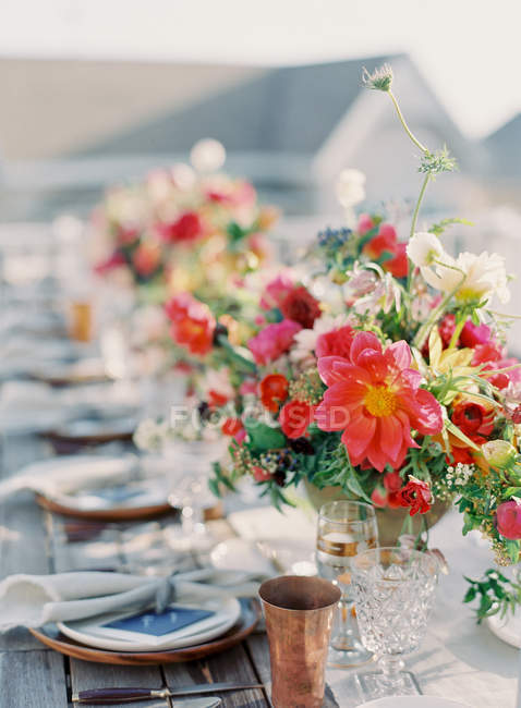 Floral arrangement on setting table — Stock Photo