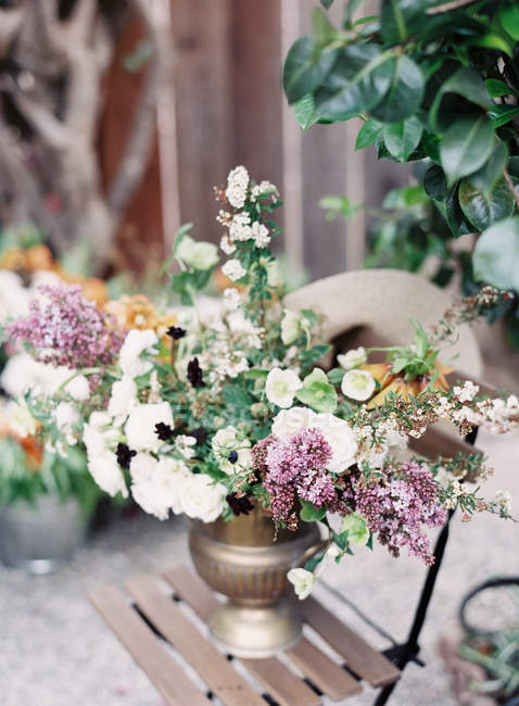 Fresh cut flowers in antique vase — Stock Photo