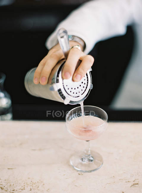 Бармен наливає коктейль у склянку — стокове фото