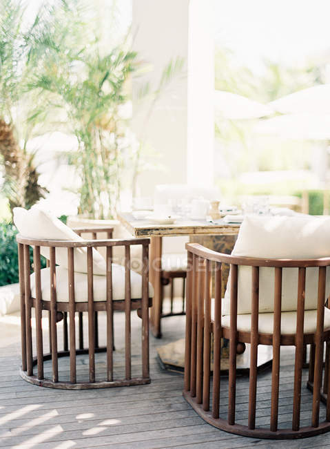 Chaises installées sur la terrasse avec palmiers en pot — Photo de stock
