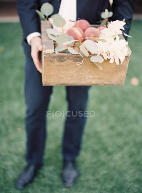 Mann hält Schachtel mit frischen Pfirsichen — Stockfoto