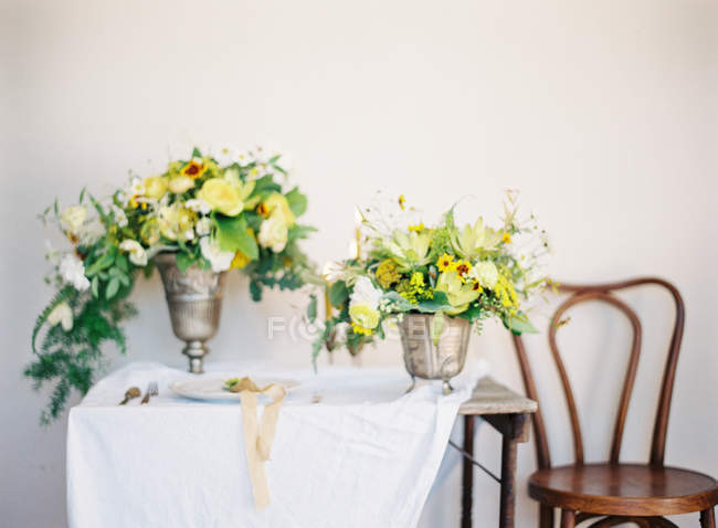 Bouquets of flowers in antique vases — Stock Photo