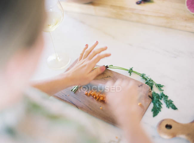 Жінка нарізає свіжу моркву — стокове фото