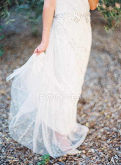 Mulher em vestido de noiva de pé ao ar livre — Fotografia de Stock