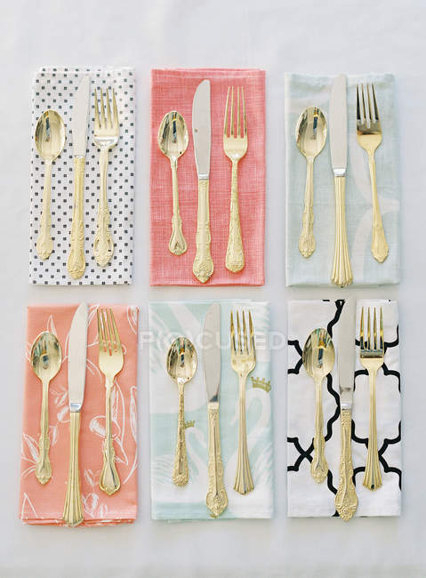 Cutlery on colorful patterned napkins — Stock Photo