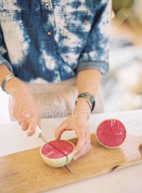 Mujer cortando queso en la tabla de cortar - foto de stock