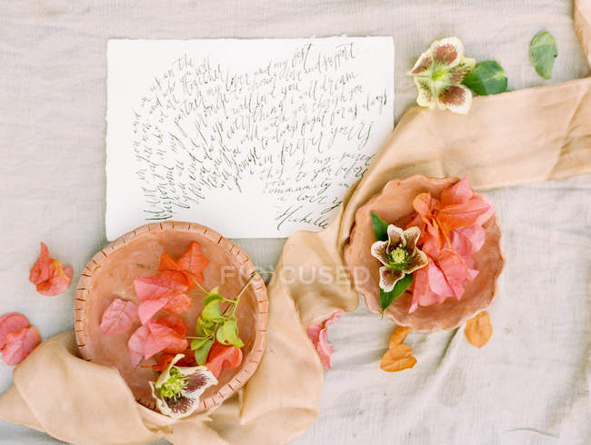Flower petals and handwritten card — Stock Photo