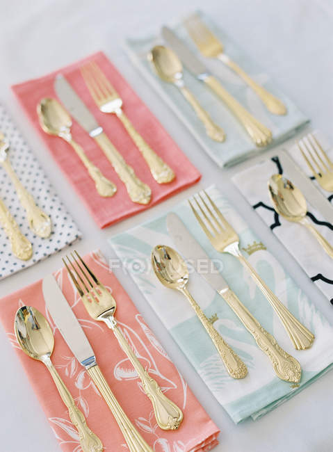 Cutlery on colorful patterned napkins — Stock Photo