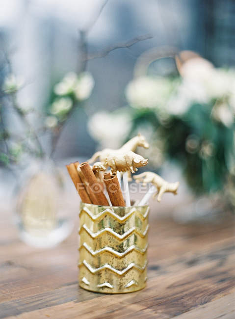 Decorative cup with cinnamon sticks — Stock Photo