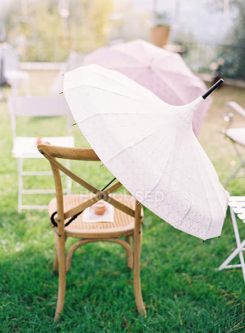 Дерев'яні стільці і парасольки — стокове фото