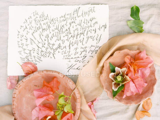 Pétales de fleurs et carte manuscrite — Photo de stock
