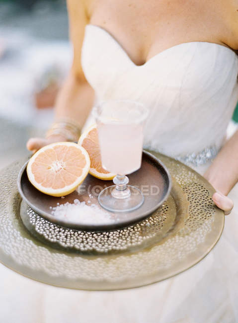 Braut trägt Tablett mit geschnittener Grapefruit — Stockfoto