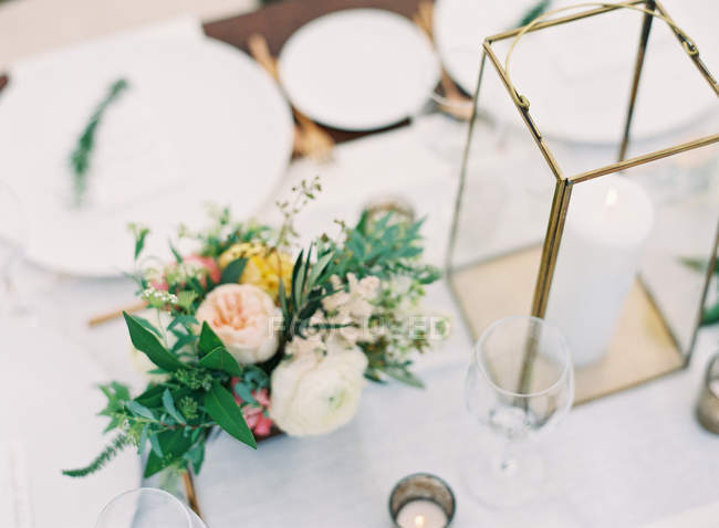 Bouquet and candles on setting table — Stock Photo
