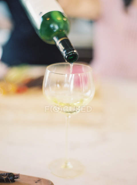Versando il vino bianco nel bicchiere — Foto stock