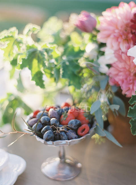 Fresh berries in antique metal stand — Stock Photo