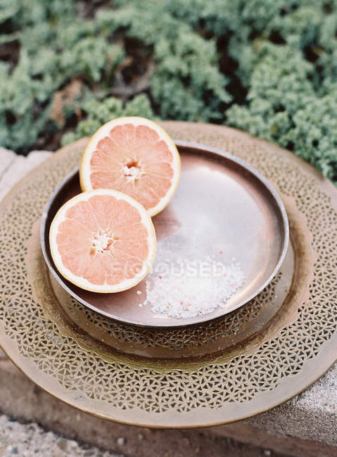 Moitié orange sur un plat en métal antiquaire — Photo de stock