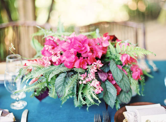 Beutiful pink bouquet on setting table — Stock Photo