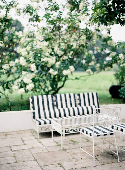 Garden with sofa and table — Stock Photo