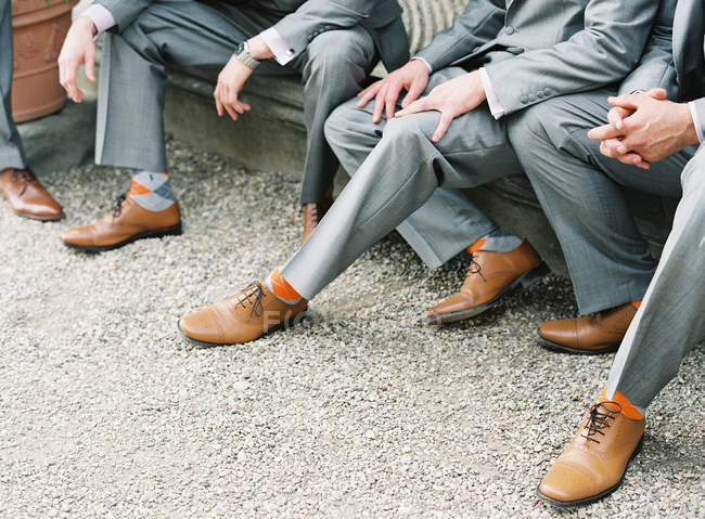 Männer in Anzügen sitzen draußen — Stockfoto