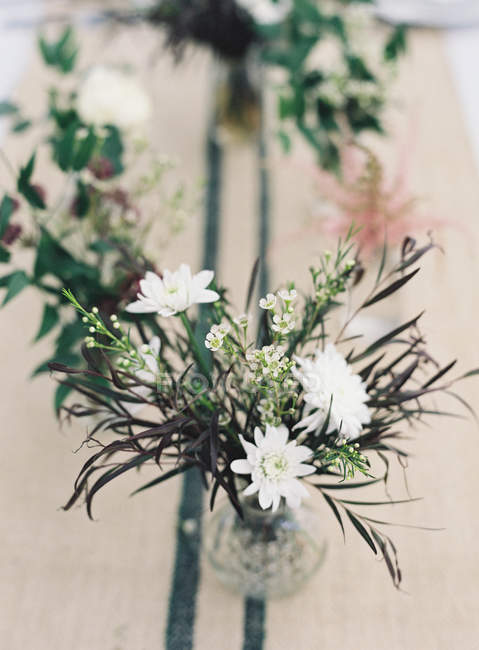 Mazzi di fiori in vasi e su tavola — Foto stock