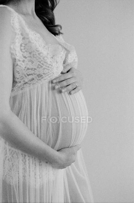 Pregnant woman with hands on tummy — Stock Photo