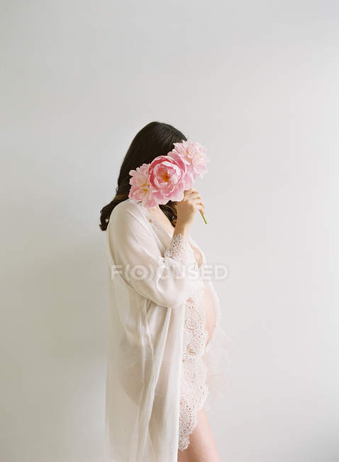 Pregnant woman with bunch of peony — Stock Photo