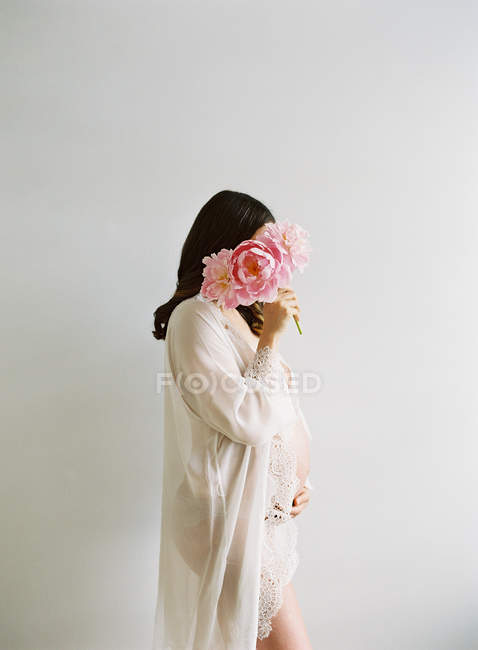 Mujer embarazada con montón de peonía - foto de stock