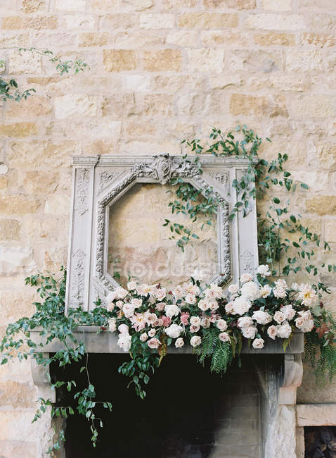 Fireplace decorated with flowers — Stock Photo