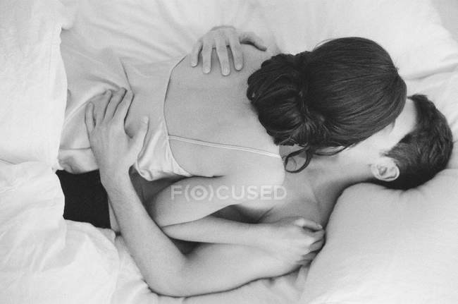 Frau liegt auf Mann im Bett — Stockfoto