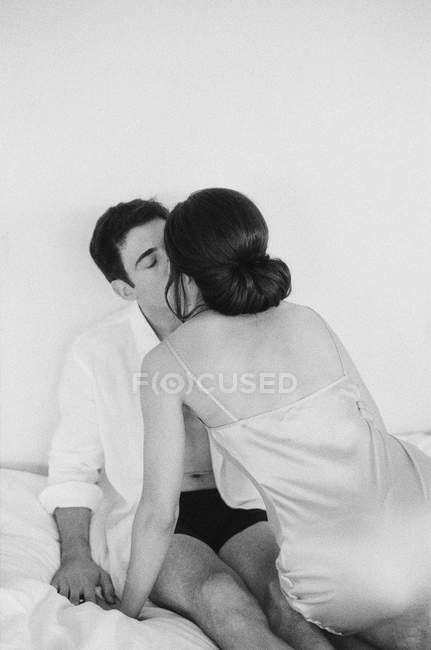 Mujer inclinada hacia adelante y besándose hombre - foto de stock