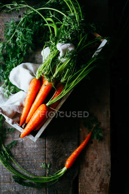 Raw carrots in wooden box — Stock Photo